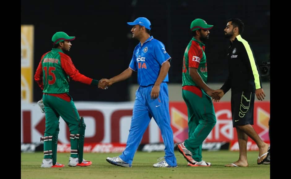 Bangladesh’s team members Mushfiqur Rahim, left, and Tamim Iqbal, second right, shake hands with India’s captain MS Dhoni, second left, and Virat Kohli after their win over India during the first one-day international cricket match between them in Dhaka, Bangladesh, Thursday, June 18, 2015. Bangladesh won by 79 runs. (AP Photo/A.M. Ahad)