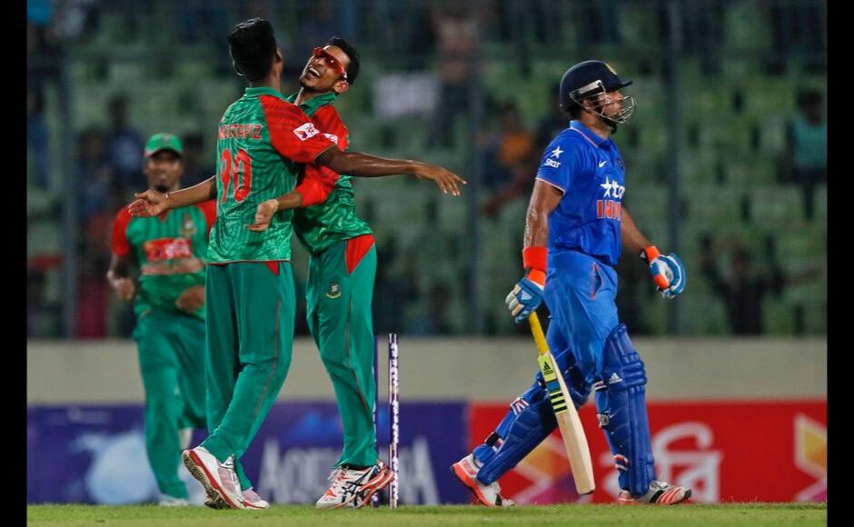 Bangladesh’s Mustafizur Rahman, left, celebrates with teammate Nasir Hossain, center, the dismissal of India’s Suresh Raina, right, during the first one-day international cricket match between them in Dhaka, Bangladesh, Thursday, June 18, 2015. (AP Photo/ A.M. Ahad) 