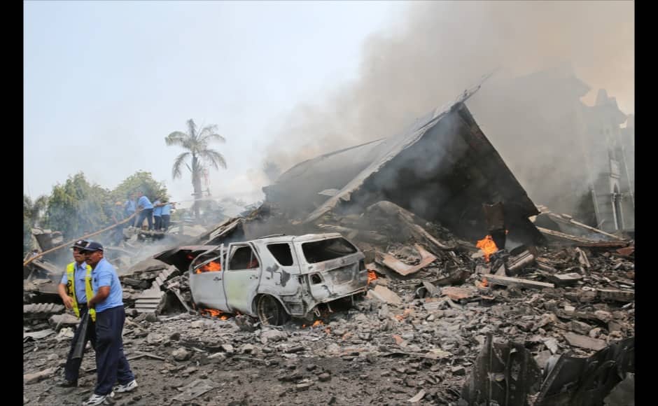 Military personnel attempt to extinguish fire at the site where an air force cargo plane crashed in Medan, North Sumatra, Indonesia, Tuesday, June 30, 2015. The Hercules C-130 plane has crashed into a residential neighborhood in the country's third-largest city Medan. (AP Photo/Hafiz)