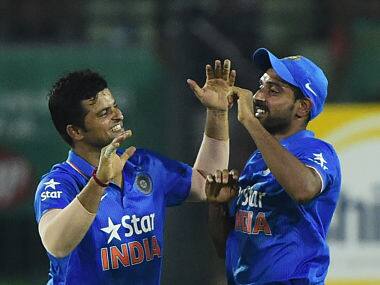 Suresh Raina (L) celebrates with teammate Dhawal Kulkarni after the dismissal of Bangladesh cricketer Shakib Al Hasan during the third ODI. AFP