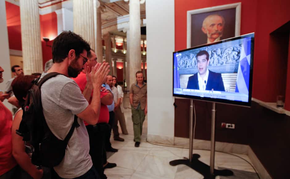 'No' supporters watch Greek Prime Minister Alexis Tsipras speaking on TV at Zappeion conference centre in Athens, Greece July 5, 2015. Greeks voted overwhelmingly 