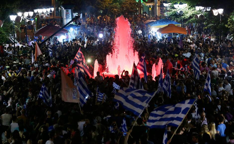 Supporters of the No vote wave Greek flags after the results of the referendum at Syntagma square in Athens, Sunday, July 5, 2015. Greece faced an uncharted future as officials counted the results of a referendum Sunday on whether to accept creditors' demands for more austerity in exchange for rescue loans, with three opinion polls showing a tight race with a narrow victory likely for the 