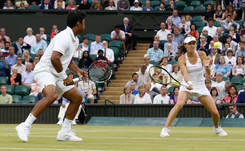 Leander Paes of India, left, and Martina Hingis of Switzerland return a ball during the mixed doubles final against Alexander Peya of Austria and Timea Babos of Hungary at the All England Lawn Tennis Championships in Wimbledon, London, Sunday July 12, 2015. (AP Photo/Alastair Grant)