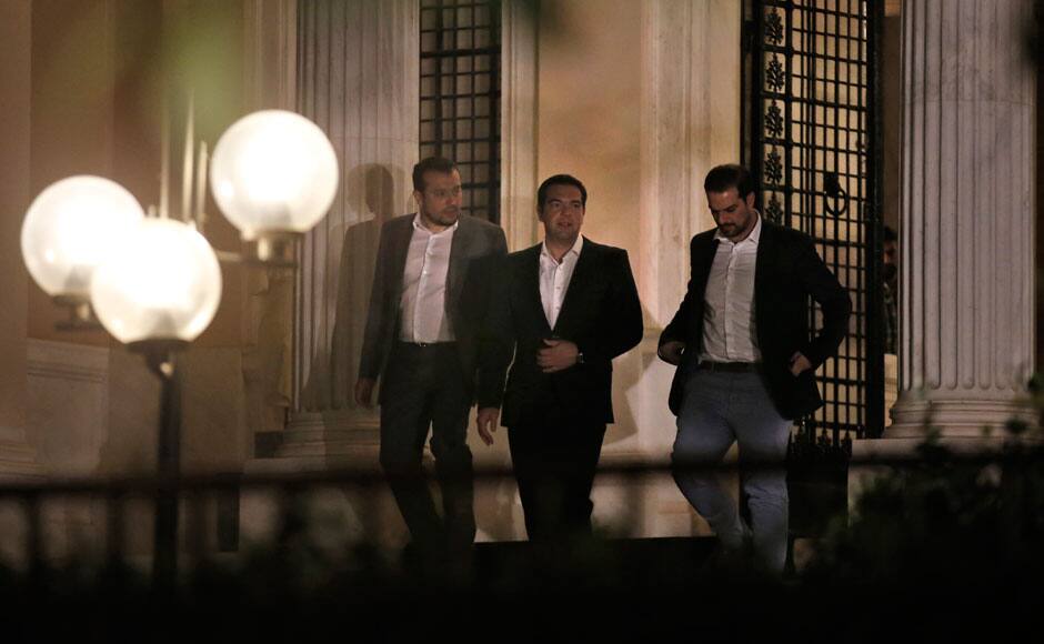 Greek Prime Minister Alexis Tspiras (C), accompanied by security agents, leaves his offices in Athens, Greece July 5, 2015. Greeks voted overwhelmingly 