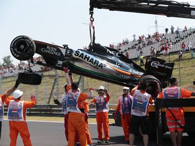 The car of Force India driver Sergio Perez of Mexico is being towed away after it turned over during the first practice session of the Formula One Hungarian Grand Prix. AFP