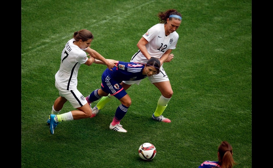 Jul 5, 2015; Vancouver, British Columbia, CAN; Japan defender Aya Sameshima (5) goes after the ball against United States midfielder Tobin Heath (17) and midfielder Lauren Holiday (12) during the second half of the final of the FIFA 2015 Women's World Cup at BC Place Stadium. Mandatory Credit: Erich Schlegel-USA TODAY Sports - RTX1J54T