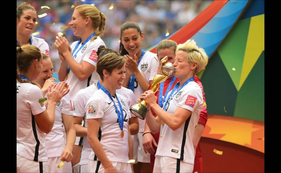 Jul 5, 2015; Vancouver, British Columbia, CAN; United States defender Meghan Klingenberg (22) looks on as teammate United States midfielder Megan Rapinoe (15) kisses the FIFA Women's World Cup trophy after defeating Japan in the final of the FIFA 2015 Women's World Cup at BC Place Stadium. The United States won 5-2. Mandatory Credit: Anne-Marie Sorvin-USA TODAY Sports - RTX1J5BZ