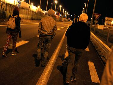 Migrants walk on a road outside the Eurotunnel area, in Calais on Wednesday. AP 