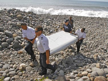 In this photo dated Wednesday, July 29, 2015, French police officers carry a piece of debris from a plane in Saint-Andre, Reunion Island. AP
