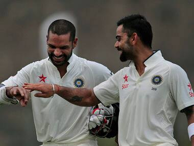 Shikar Dhawan, left, and Virat Kohli share a light moment during the second day of their first Test. AP