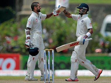 Shikar Dhawan, left, celebrates scoring a century with teammate Virat Kohli during the second day of their first Test. AP
