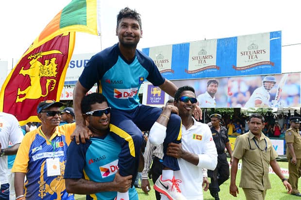 Kumar Sangakkara (C) gestures to the crowd as his teammates Dhammika Prasad (L) and Vishwa Fernando (R) carry him around the pitch in a lap of honour after the 2nd Test. AFP