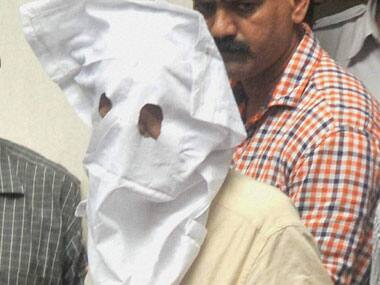 Sanjeev Khanna (face covered) before being produced in a local court. PTI