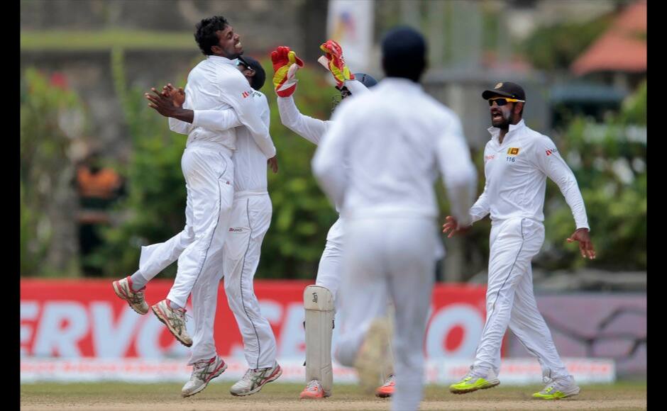 Sri Lanka's Tharindu Kaushal, left, celebrates with teammates the dismissal of India's captain Virat Kohli during the fourth day of their first test cricket match in Galle, Sri Lanka, Saturday, Aug. 15, 2015. (AP Photo/Eranga Jayawardena)