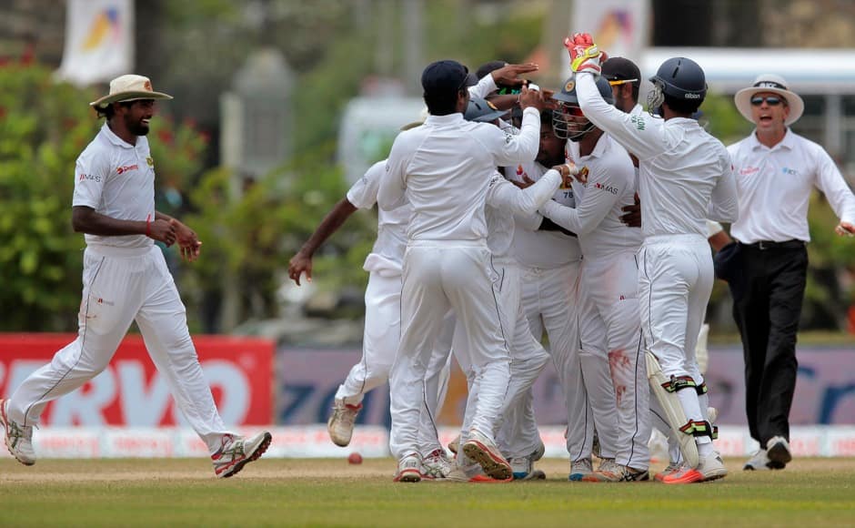 Sri Lankan team members celebrate the dismissal of Wriddhiman Saha during the fourth day of their first test cricket match in Galle, Sri Lanka, Saturday, Aug. 15, 2015. (AP Photo/Eranga Jayawardena)