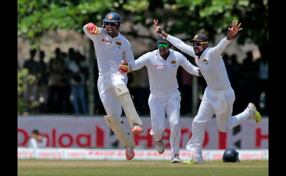 Sri Lankan team members celebrate the dismissal of India's captain Virat Kohli during the fourth day of their first test cricket match in Galle, Sri Lanka, Saturday, Aug. 15, 2015. (AP Photo/Eranga Jayawardena)