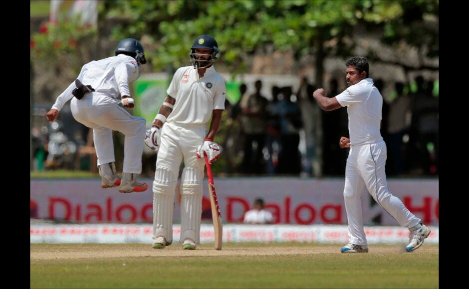 Sri Lanka's Rangana Herath, right, celebrates the dismissal of India's Rohit Sharma during the fourth day of their first test cricket match in Galle, Sri Lanka, Saturday, Aug. 15, 2015. (AP Photo/Eranga Jayawardena)