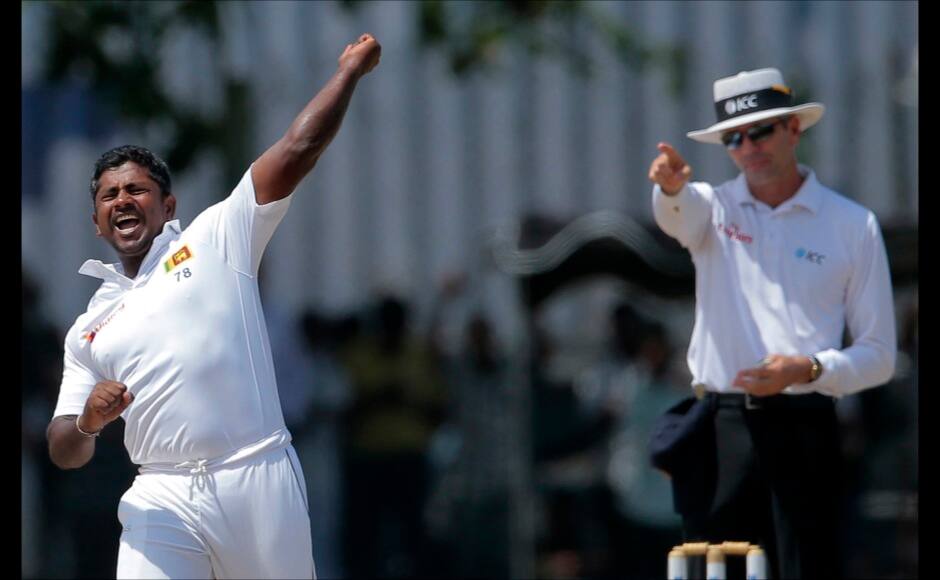 Sri Lanka's Rangana Herath, left, celebrates the dismissal of India's Ishant Sharma as the umpire signals his decision during the fourth day of their first test cricket match in Galle, Sri Lanka, Saturday, Aug. 15, 2015. (AP Photo/Eranga Jayawardena)