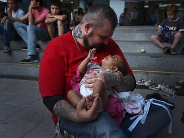 Volunteer Baba Mujhse holds a newly-arrived migrant baby in front of the Keleti railway station in Budapest, Hungary. AP