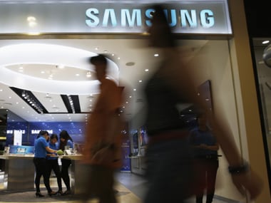 People walk in front of a Samsung smartphone showroom in Jakarta
