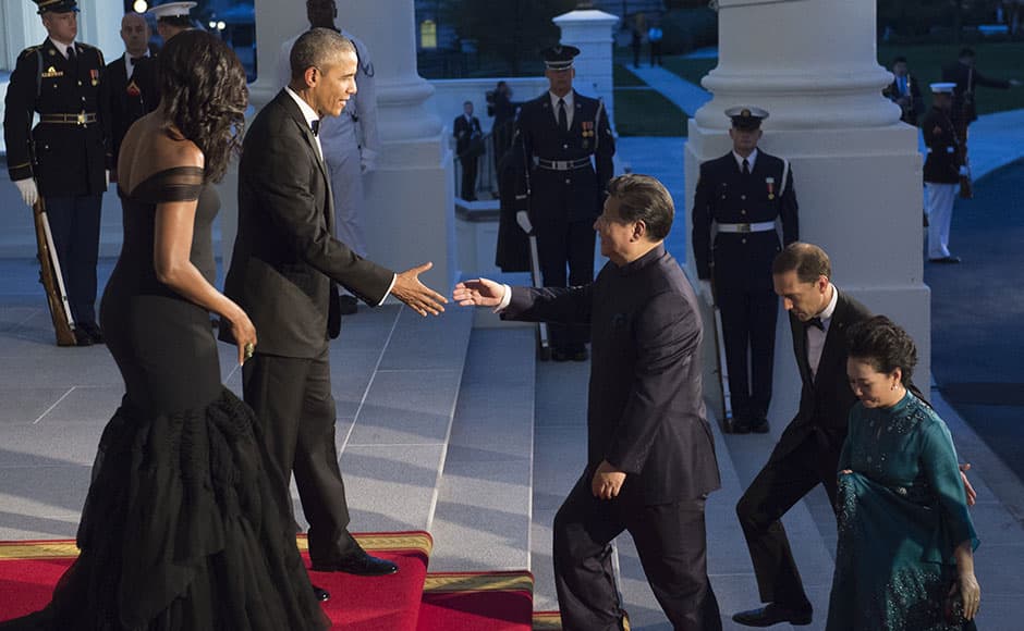 US President Barack Obama and First Lady Michelle Obama greet Chinese President Xi Jinping and his wife, Peng Liyuan, as they arrive for a State Dinner at the White House in Washington, DC, September 25, 2015. AFP