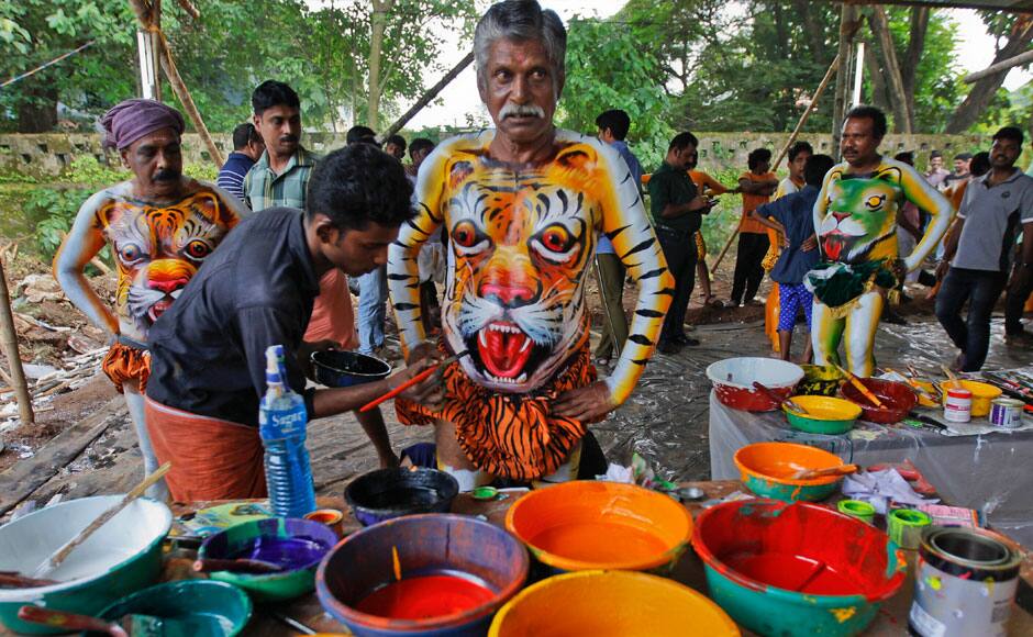 An Indian man get his body painted with the likeness of a tiger to perform during the 'Pulikali' or Tiger Dance in Thrissur, Kerala state, India, Monday, Aug. 31, 2015. This folk art festival is held every year in this town to entertain people during the harvest festival ‘Onam’. (AP Photo/Arun Sankar K.)