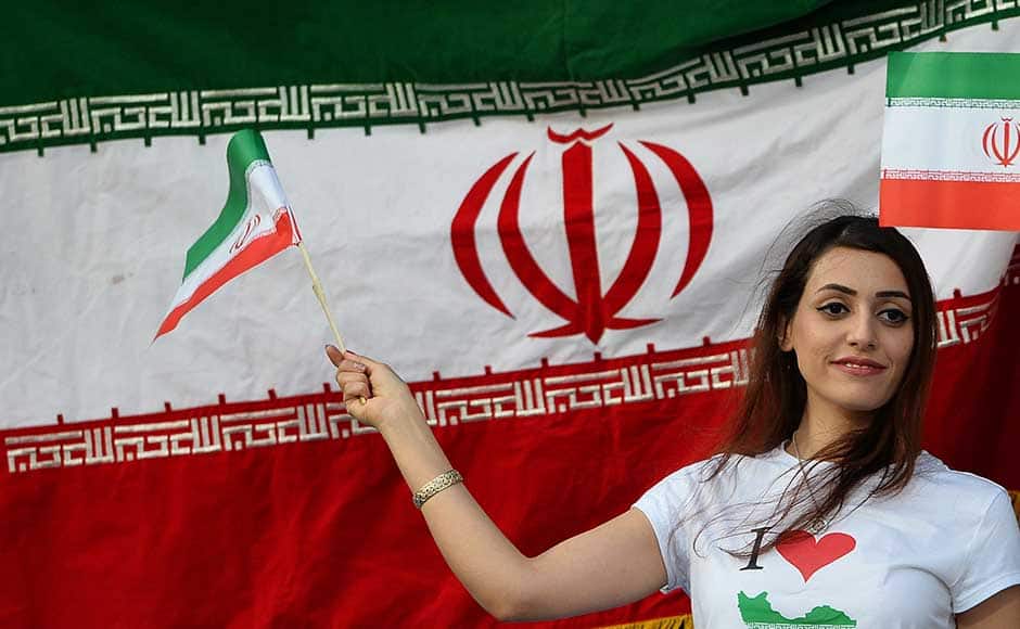 The Iran fans had thronged the stadium in numbers and their team didn't disappoint them. (In pic): An Iranian football fan stands alongside the national flag during the match. AFP