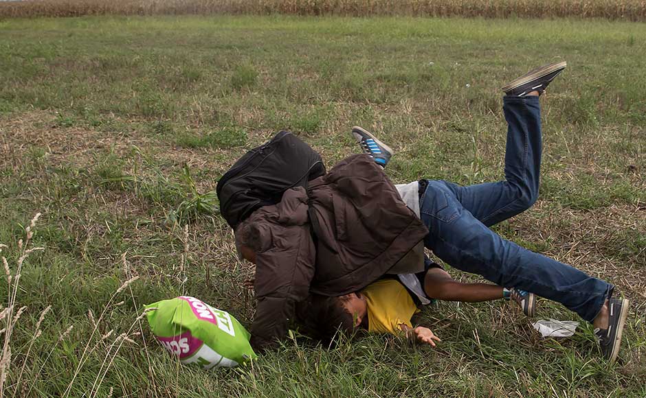 Hungarian camerawoman intentionally kicks, trips fleeing migrants