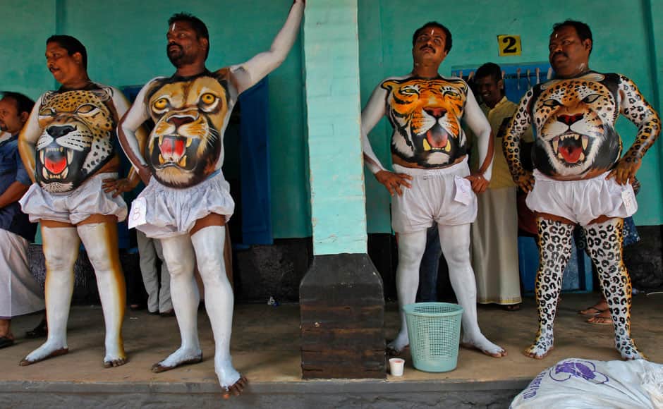 Indian men getting their bodies painted wait for the paint to dry before they perform during the 'Pulikali' or Tiger Dance in Thrissur, Kerala state, India, Monday, Aug. 31, 2015. This folk art festival is held every year in this town to entertain people during the harvest festival ‘Onam’. (AP Photo/Arun Sankar K.)
