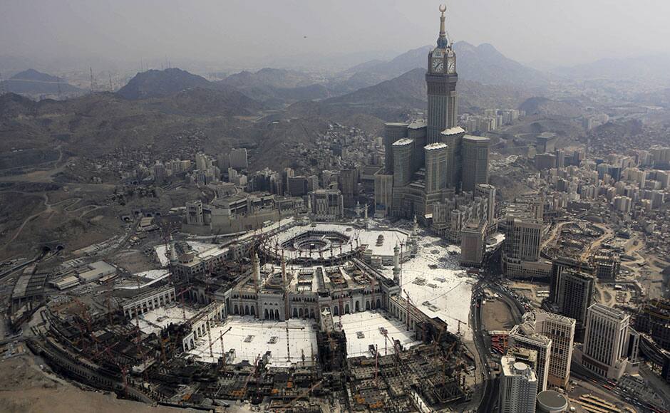 FILE - In this Sunday, Oct. 5, 2014 file photo, the Abraj Al-Bait Towers with the four-faced clocks stands over the holy Kabaa, as Muslims encircle it inside the Grand Mosque during the annual pilgrimage, known as the hajj, in the Muslim holy city of Mecca, Saudi Arabia. Saudi Arabia's civil defense authority says dozens of people have been killed after a crane collapsed on the Grand Mosque in the holy city of Mecca on Friday, Sept. 11, 2015. (AP Photo/Khalid Mohammed, File)
