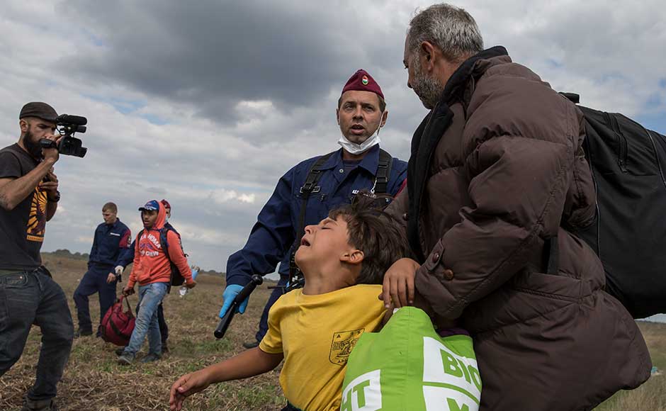 Hungarian camerawoman intentionally kicks, trips fleeing migrants