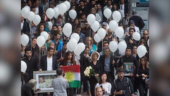 Mourners release white balloons into the sky in Vancouver to honour Syrian boys