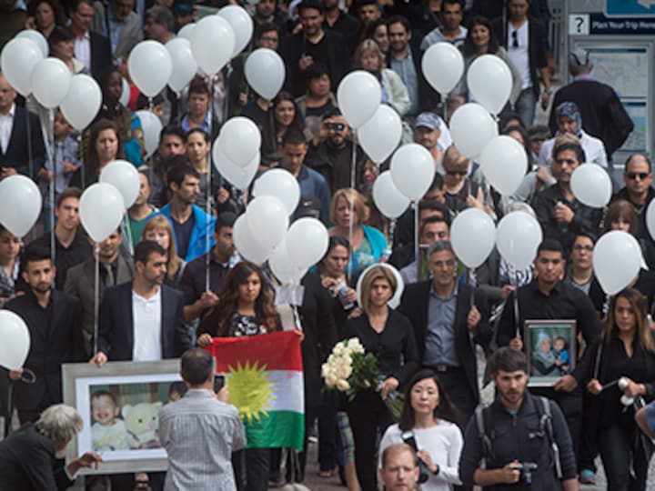 Mourners release white balloons into the sky in Vancouver to honour Syrian boys