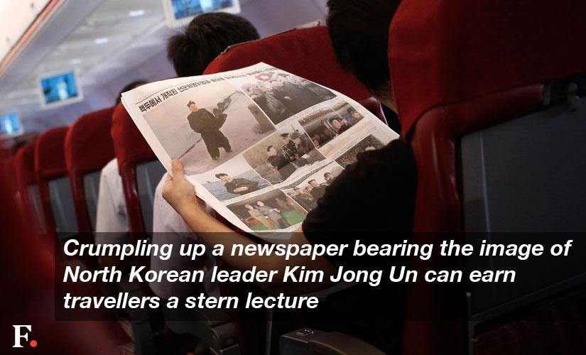 Crumpling-up-a-newspaper-bearing-the-image-of-North-Korean-leader-Kim-Jong-Un-can-earn-travellers-a-stern-lecture