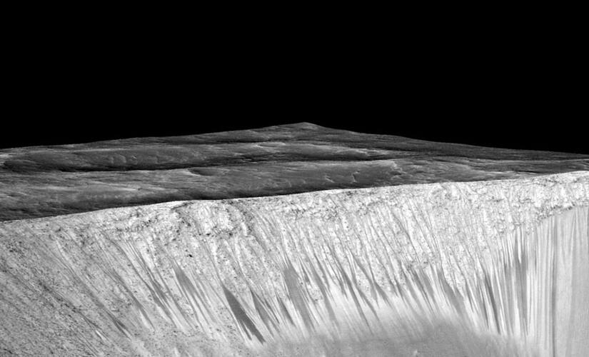 The dark narrow streaks are hypothesized to be formed by flow of briny liquid water on Mars. Image Credit: Nasa