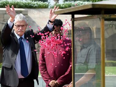 Mogens Lykketoft throws rose petals as he pays his respects at Raj Ghat on 30 August. AFP 
