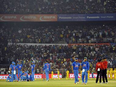 Cricketers and match officials look on as play is interrupted by spectators throwing bottles onto the pitch during the second T20I between India and South Africa at The Barabati Stadium. AFP