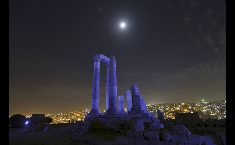 The moon is seen over the Roman pillars of the Temple of Hercules as it is lit up in blue in Amman The moon is seen over the Roman pillars of the Temple of Hercules as it is lit up in blue in Amman