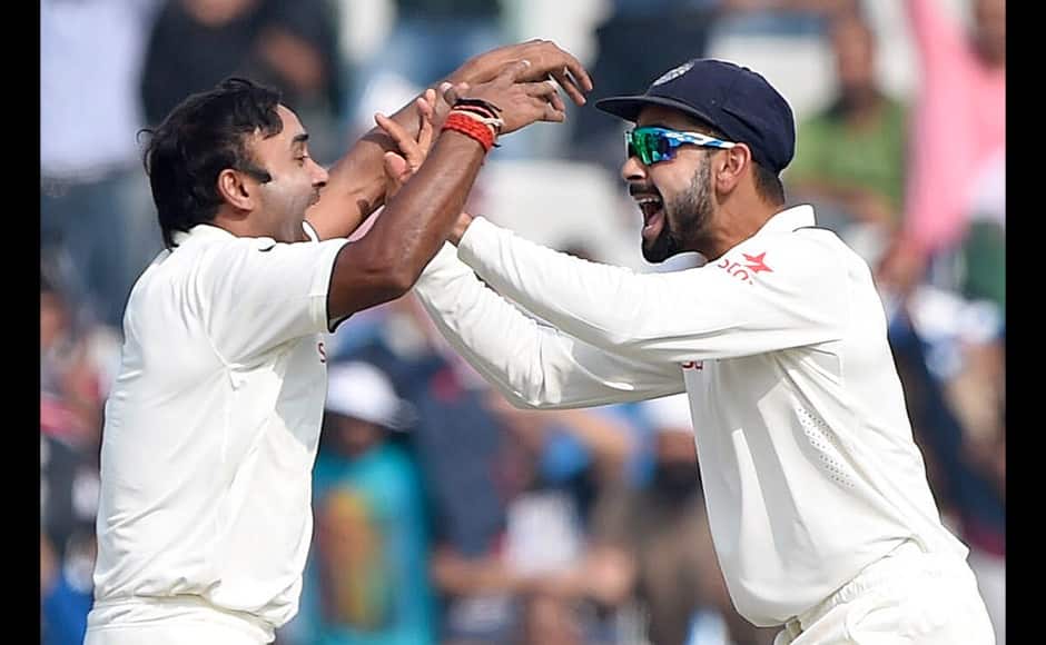 India's Amit Mishra (L) celebrates with captain Virat Kohli the wicket of South Africa's AB de Villiers during the third day of the first Test match between India and South Africa at The Punjab Cricket Association Stadium in Mohali on November 7, 2015. AFP