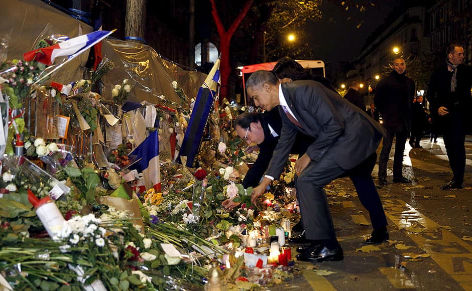 French President Francois Hollande and U.S. President Barack Obama place flowers at a makeshift memorial to pay tribute to the victims of the Paris attacks at the Bataclan in Paris November 29, 2015. REUTERS