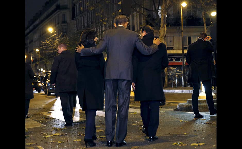 U.S. President Barack Obama, French President Francois Hollande (R) and Paris Mayor Anne Hidalgo (L) walk away after placing flowers at a makeshift memorial to pay tribute to the victims of the Paris attacks at the Bataclan in Paris November 30, 2015. REUTERS
