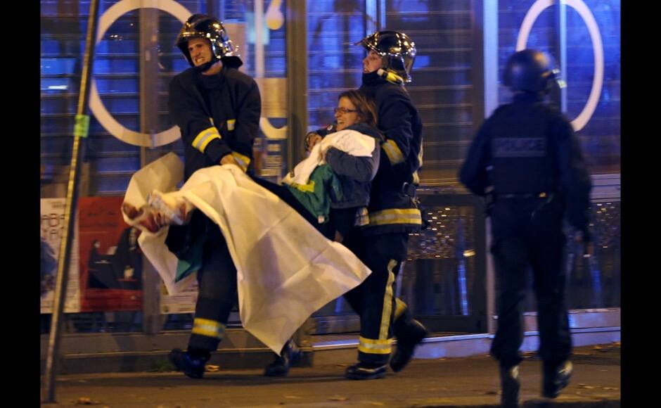 ATTENTION EDITORS - VISUAL COVERAGE OF SCENES OF INJURY French fire brigade members aid an injured individual near the Bataclan concert hall following fatal shootings in Paris, France, November 13, 2015. Gunmen and bombers attacked busy restaurants, bars and a concert hall at locations around Paris on Friday, killing dozens of people in what a shaken President Francois Hollande described as an unprecedented terrorist attack. REUTERS/Christian Hartmann TPX IMAGES OF THE DAY - RTS6W11