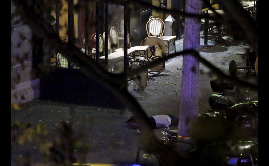 ATTENTION EDITORS - VISUAL COVERAGE OF SCENES OF INJURY OR DEATH General view of the scene where a victim is seen on the sidewalk outside a cafe near the Bataclan concert hall following fatal shootings in Paris, France, November 14, 2015. REUTERS/Christian Hartmann - RTS6WNV