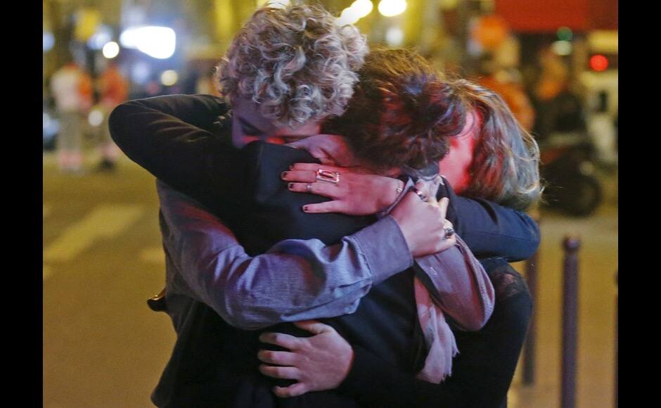 People hug on the street near the Bataclan concert hall following fatal attacks in Paris, France, November 14, 2015. Gunmen and bombers attacked busy restaurants, bars and a concert hall at locations around Paris on Friday evening, killing dozens of people in what a shaken French President described as an unprecedented terrorist attack. REUTERS/Christian Hartmann - RTS6X48