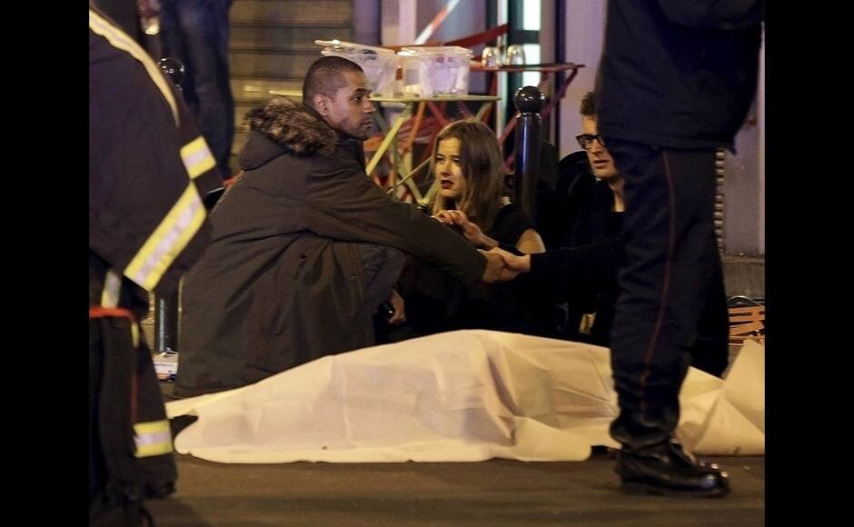 ATTENTION EDITORS - VISUAL COVERAGE OF SCENES OF INJURY OR DEATH A general view of the scene that shows rescue services personnel working near the covered bodies outside a restaurant following a shooting incident in Paris, France, November 13, 2015. REUTERS/Philippe Wojazer - RTS6XIT