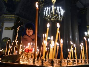 A woman lights a candle in Kazansky Cathedral in St.Petersburg on 2 November, 2015, in memory of the victims of the jetliner crash. AFP