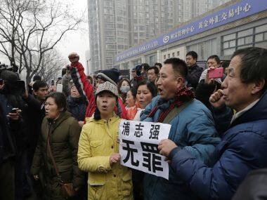 Supporters of prominent rights lawyer Pu Zhiqiang chant slogans. The placard reads: 
