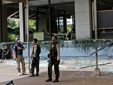 Police officers stand guard outside a damaged Starbucks cafe after an attack in Jakarta on Thursday. AP