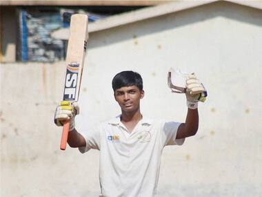 Pranav Dhanawade raises his bat, after a reaching a 1000 runs. PTI
