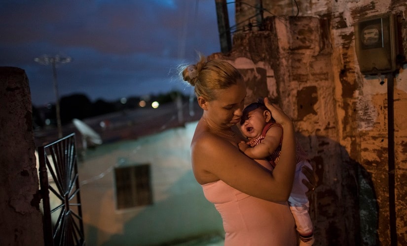 Gleyse Kelly da Silva, 27, holds her daughter Maria Giovanna, who was born with microcephaly, outside their house in Recife, Brazil. AP